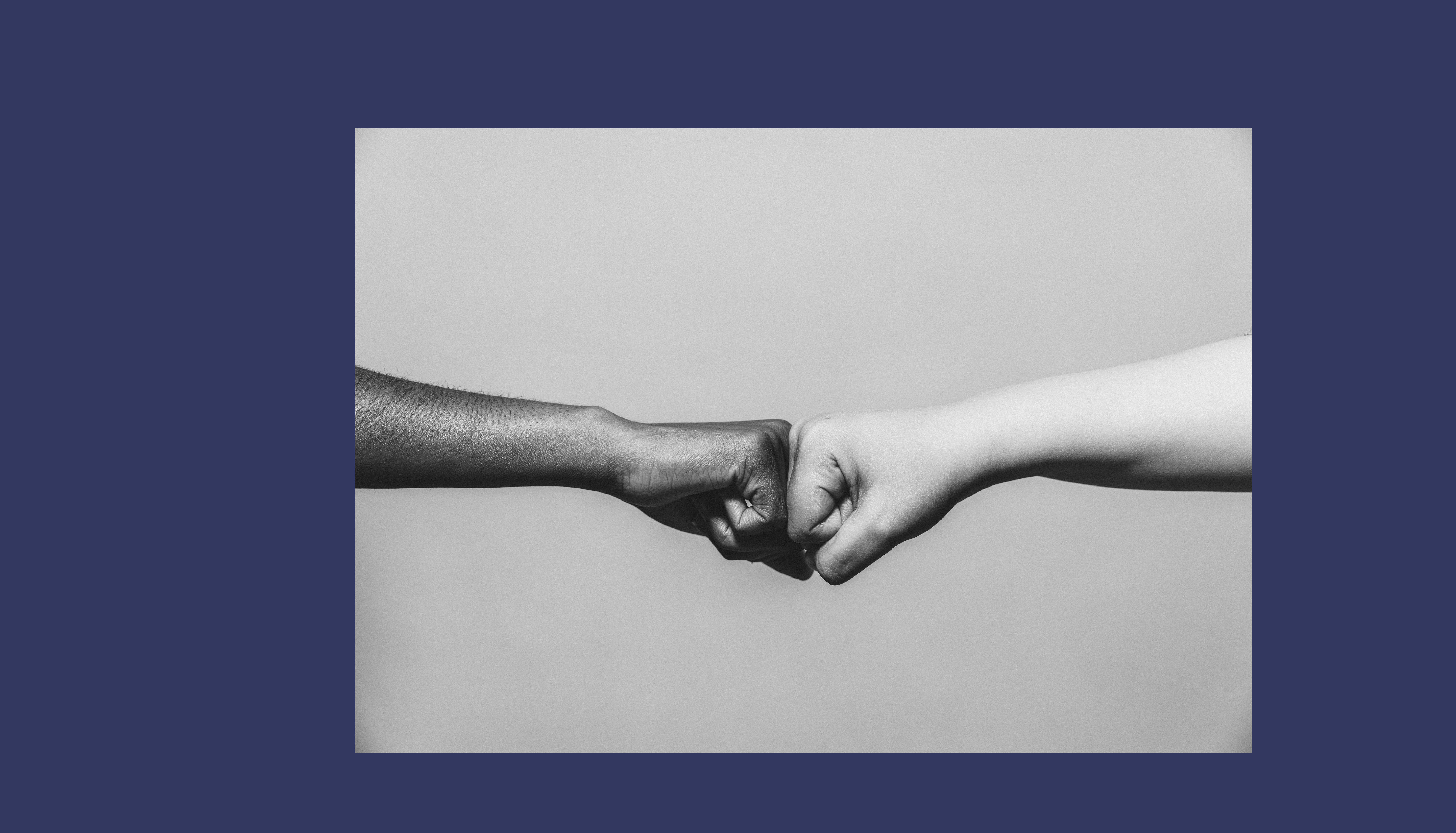 Two fists against a purple background. Conceptual shot about anti-racism and teamwork.