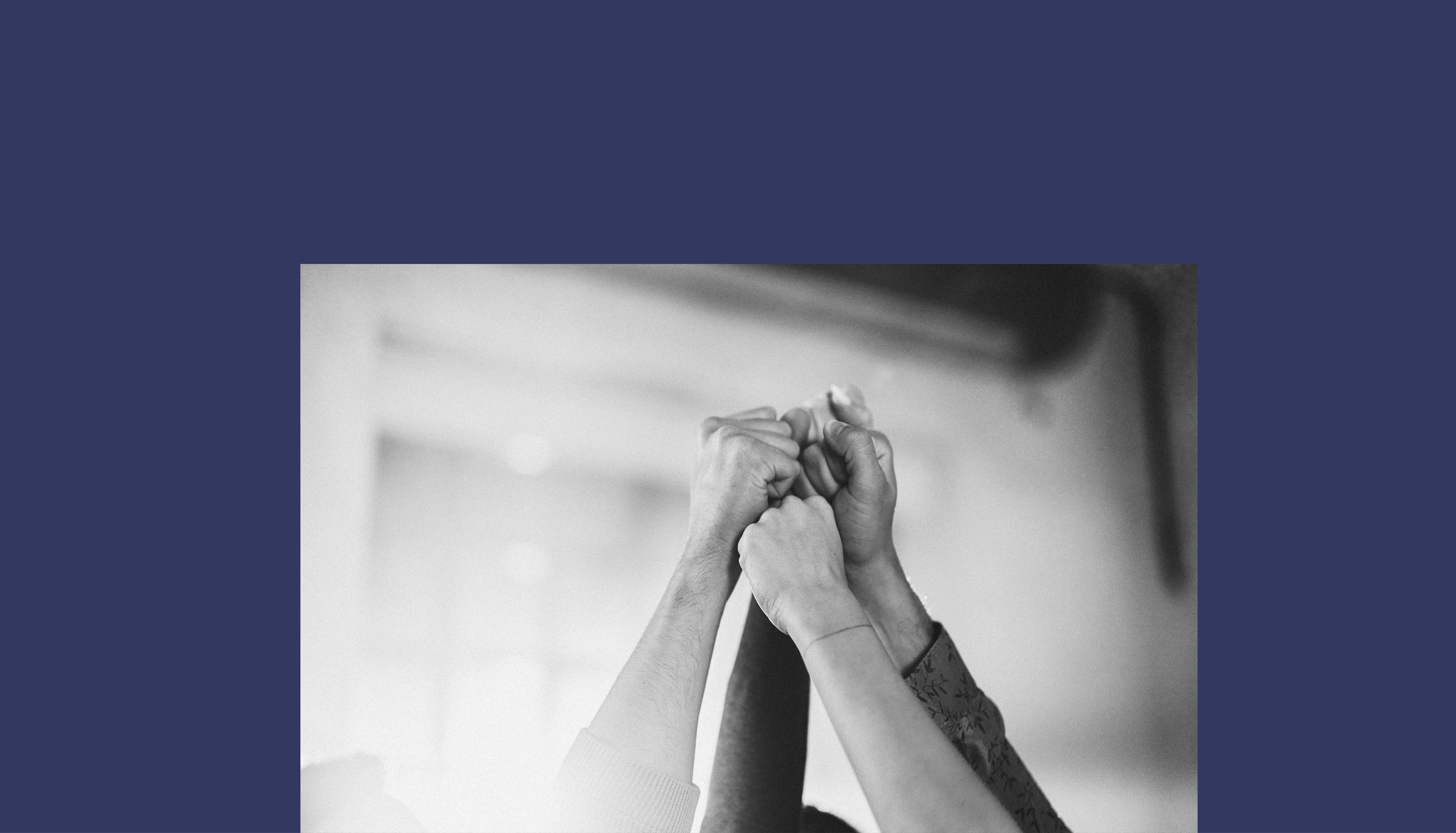Close up of group of unrecognizable people raising their fists in success.