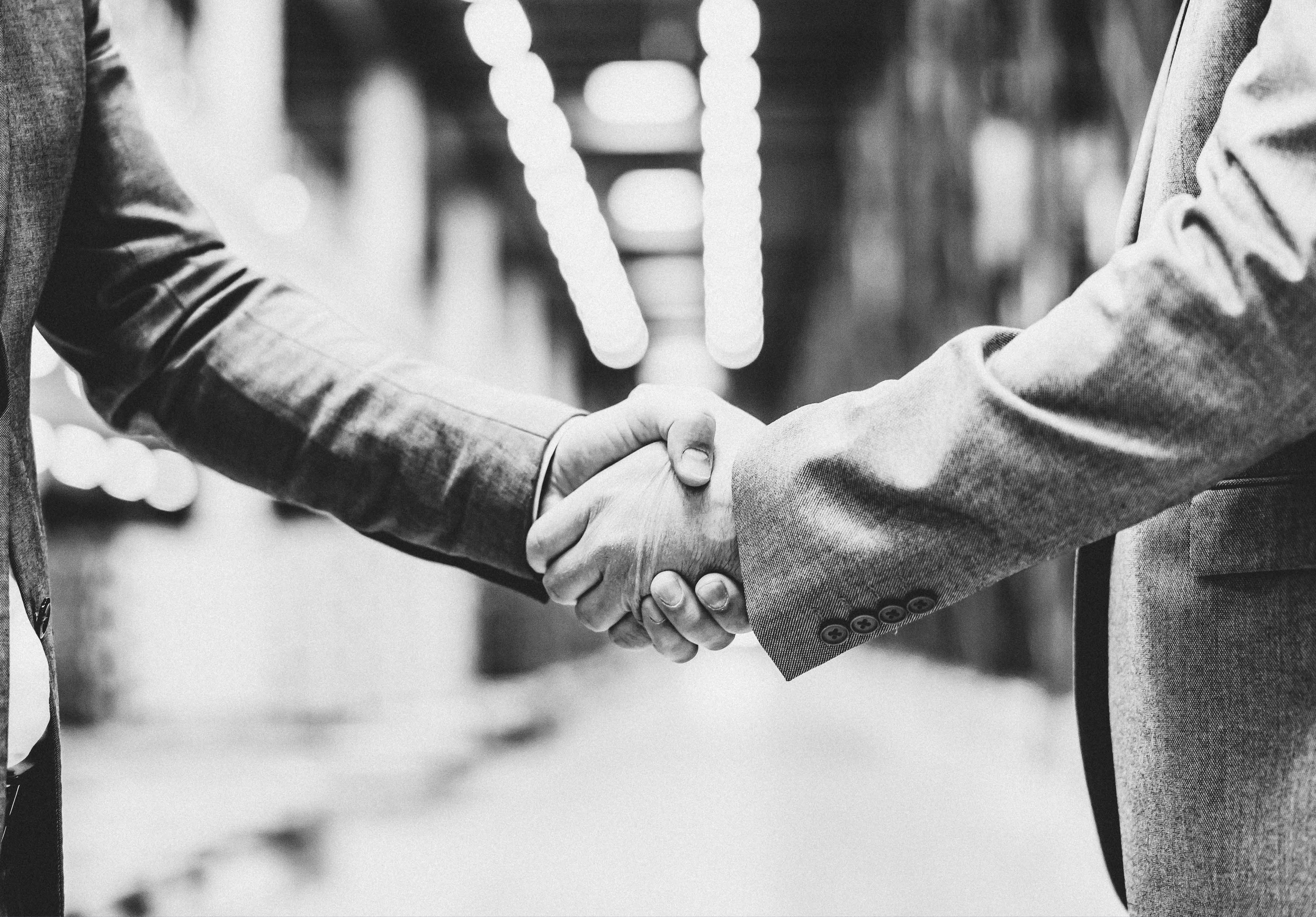 Close up of a business partners shaking hands at warehouse.